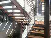 Trapper af stålprofiler, trappetrin dækket med træplader og glasrækværk